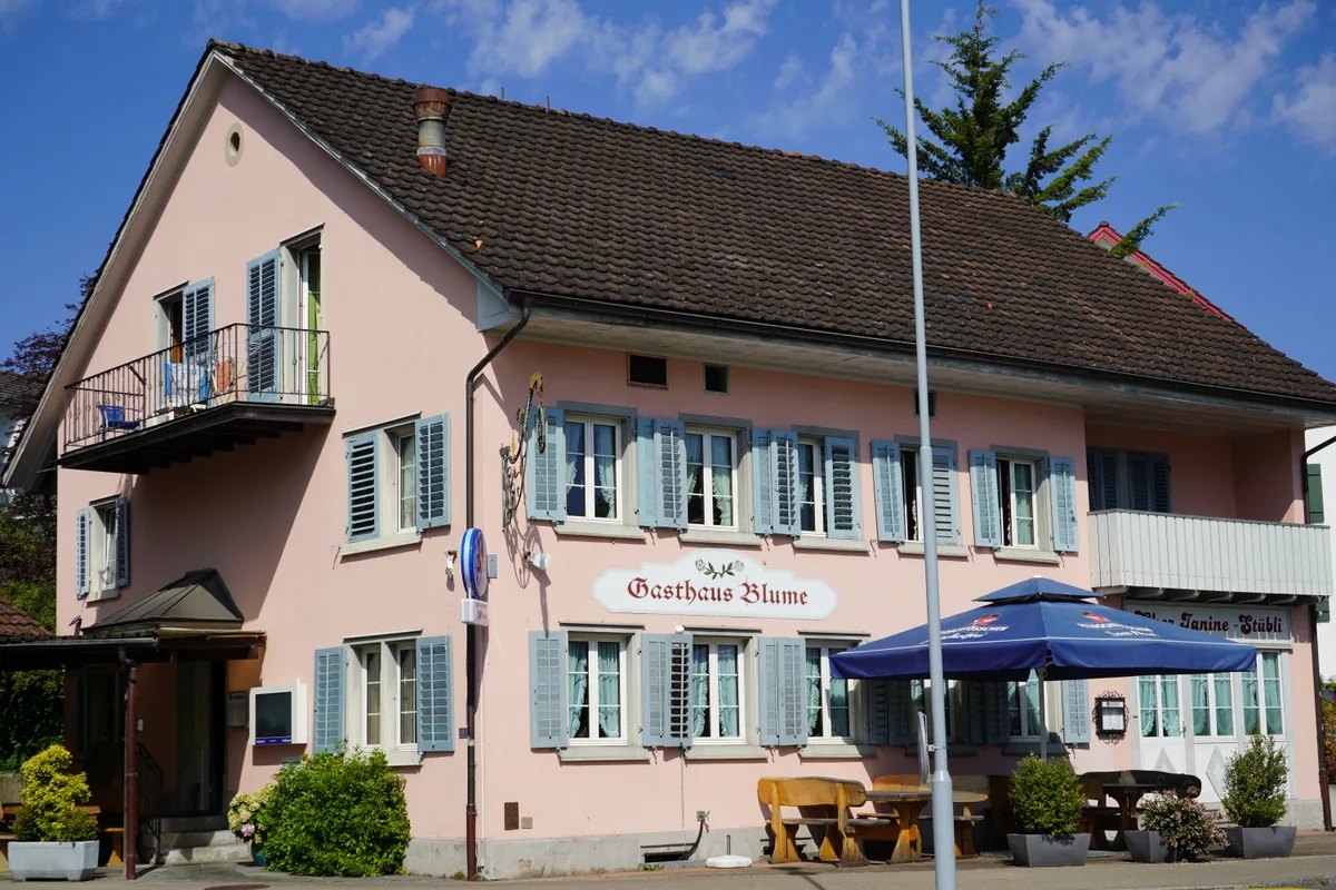 Ein Restaurant mit pinker Fassade bei sonnigem Wetter.